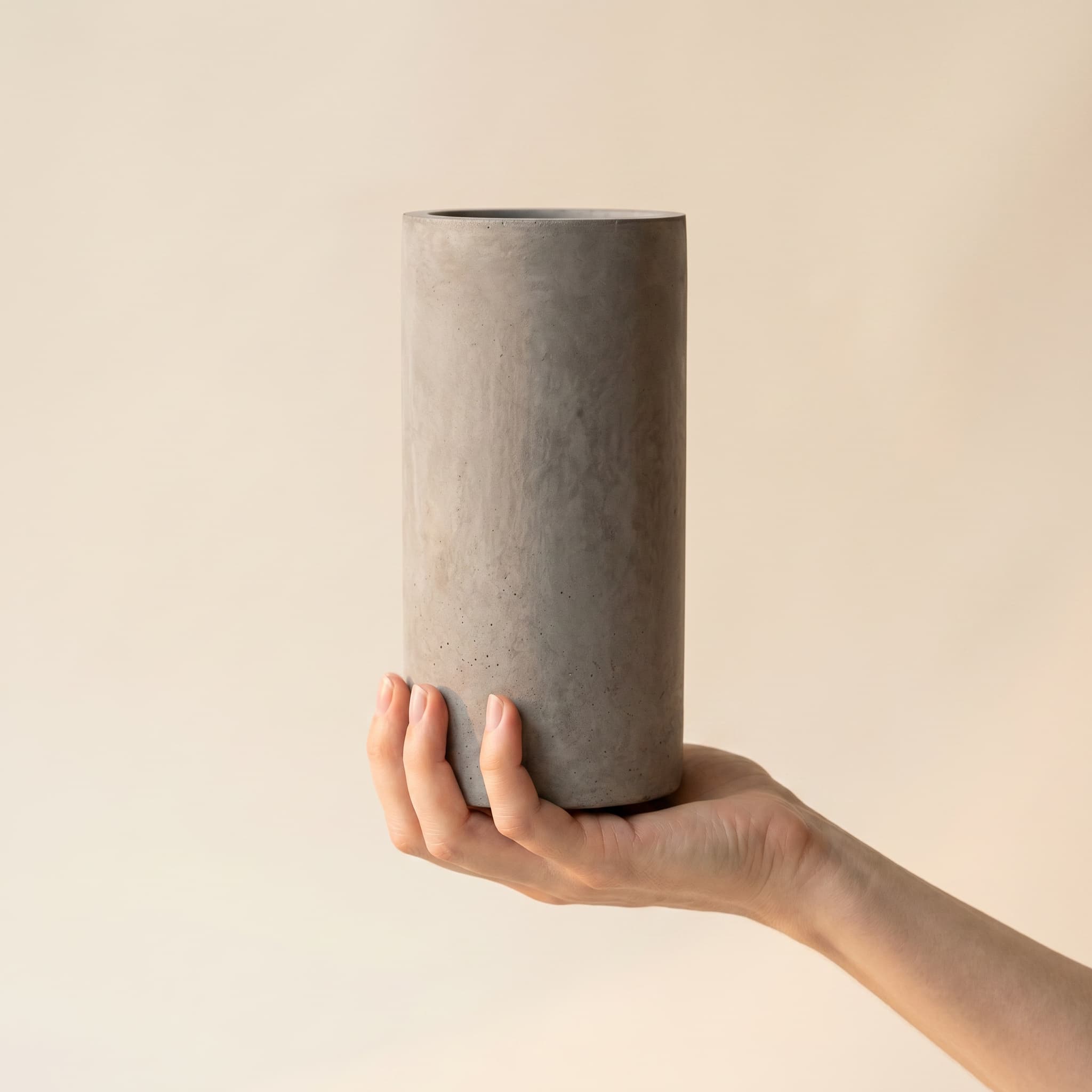 Tall grey cylinder held in a hand