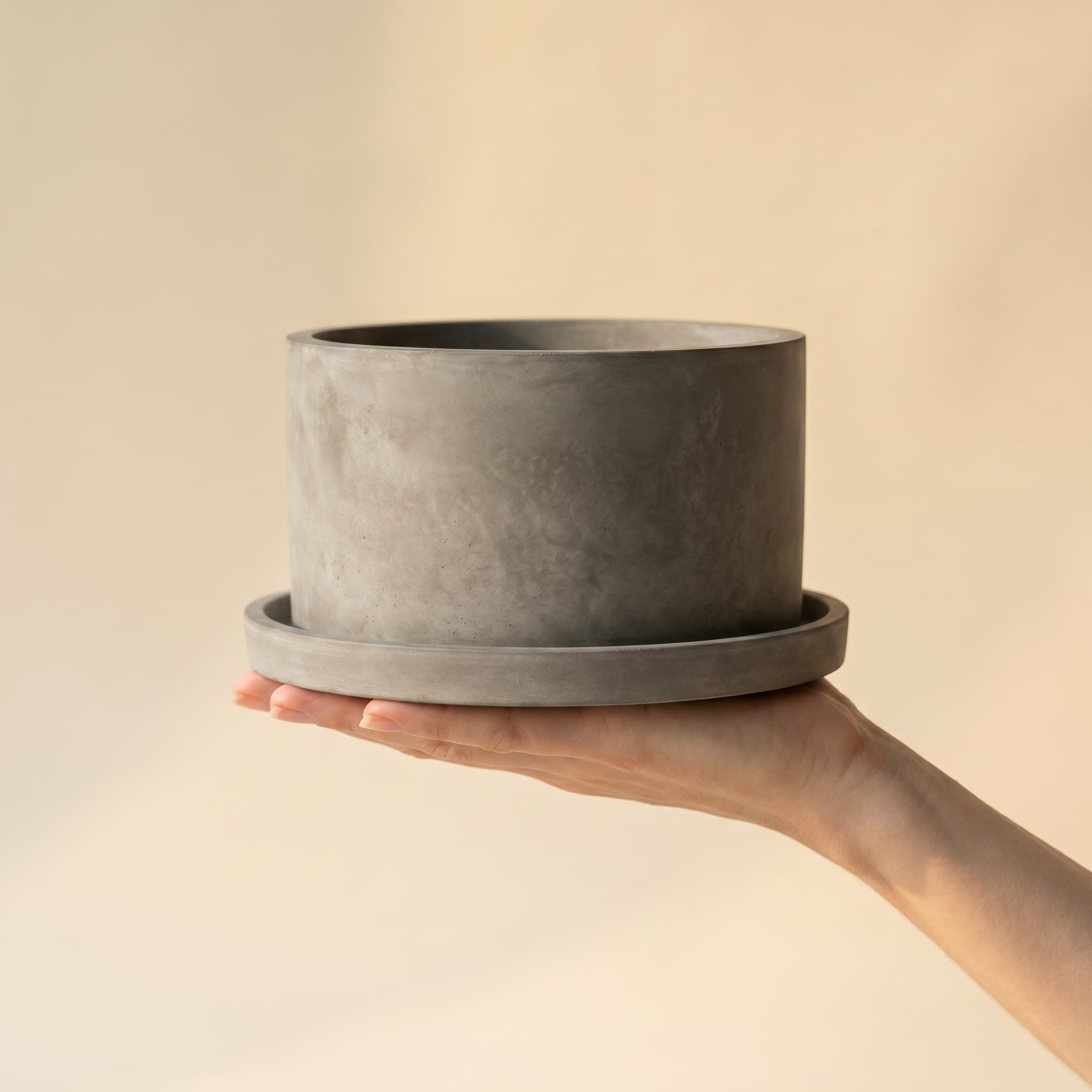 Wide grey cylinder set held in a hand