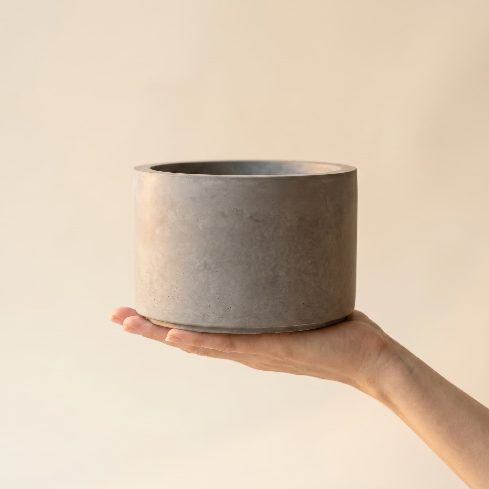 Wide grey cylinder held in a hand