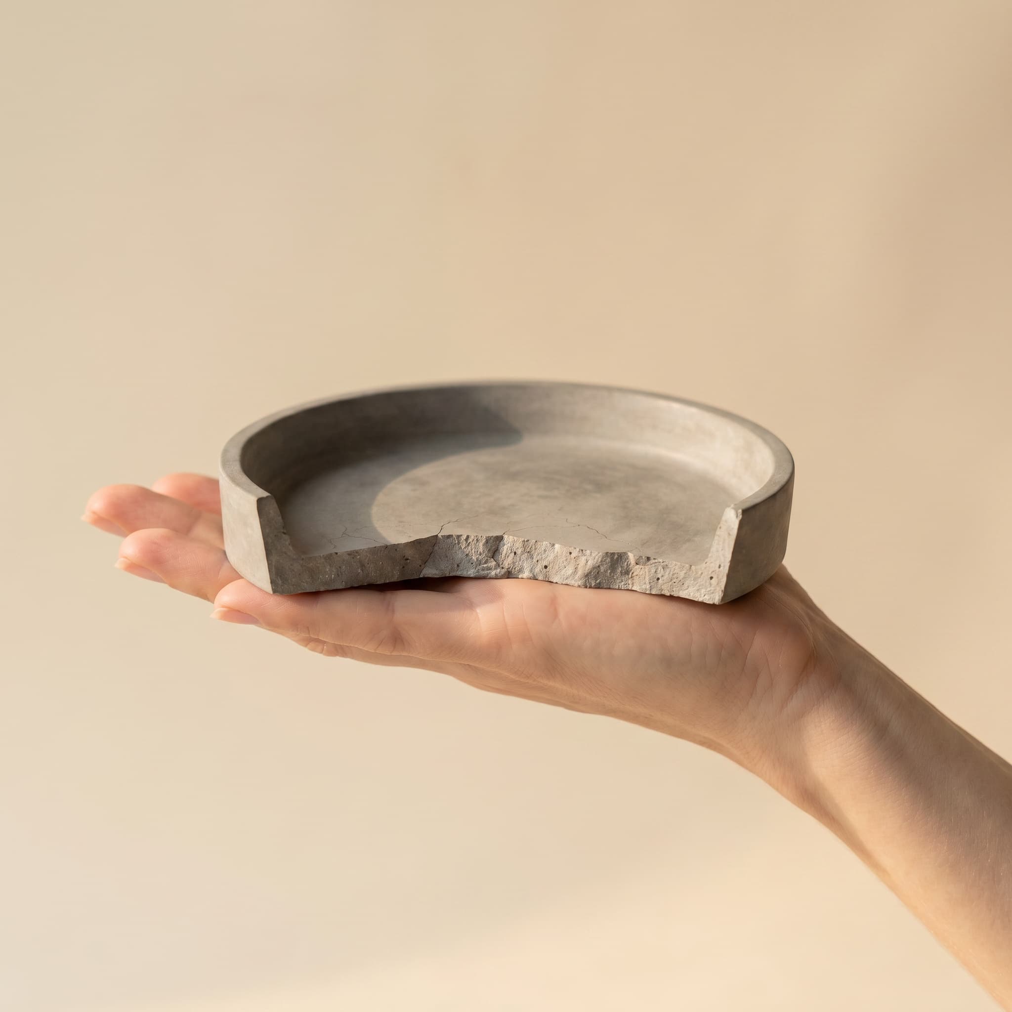 Broken round grey saucer held in a hand