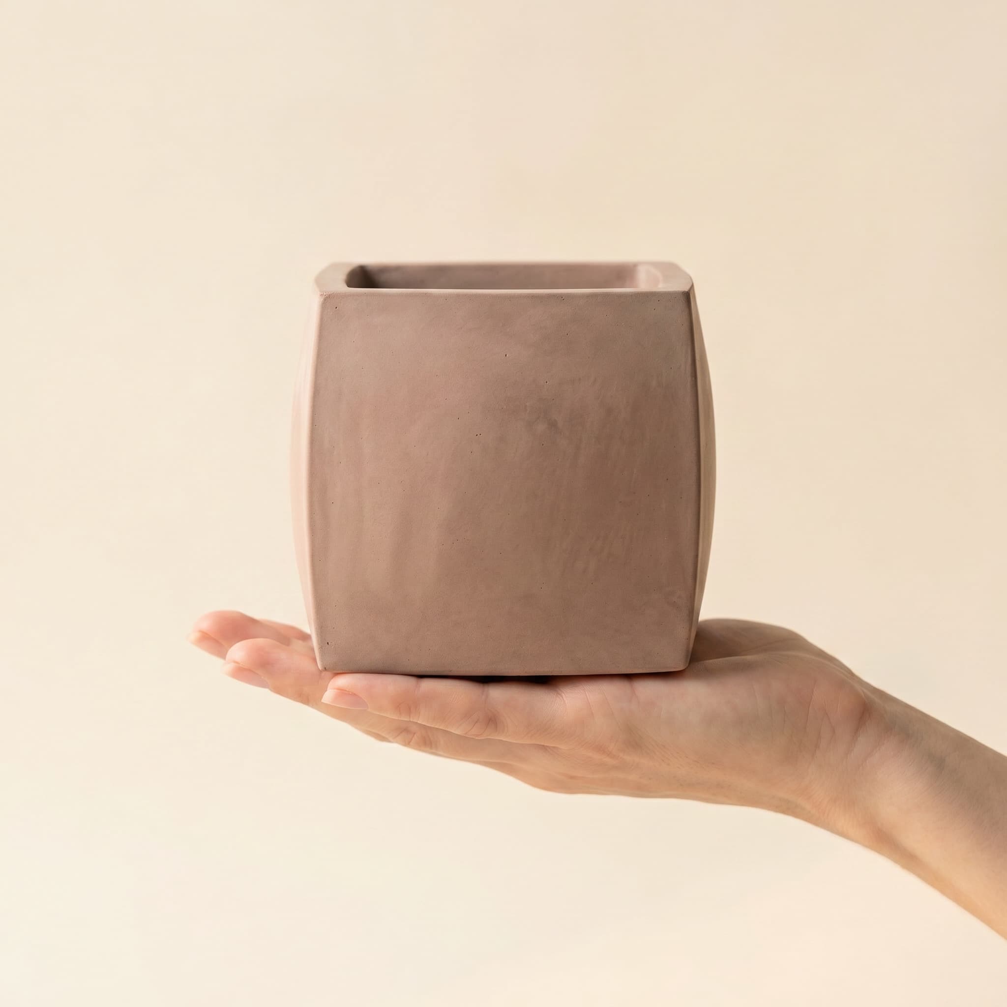 Bulbous taupe cube held in a hand