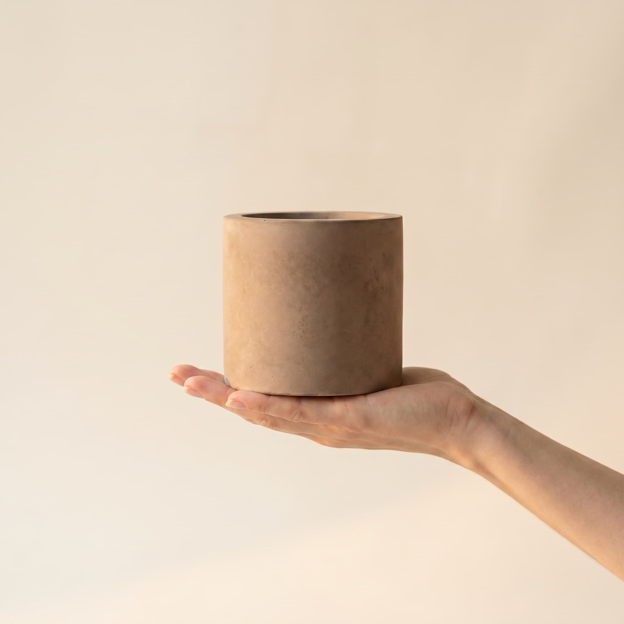 Small taupe cylinder held in a hand