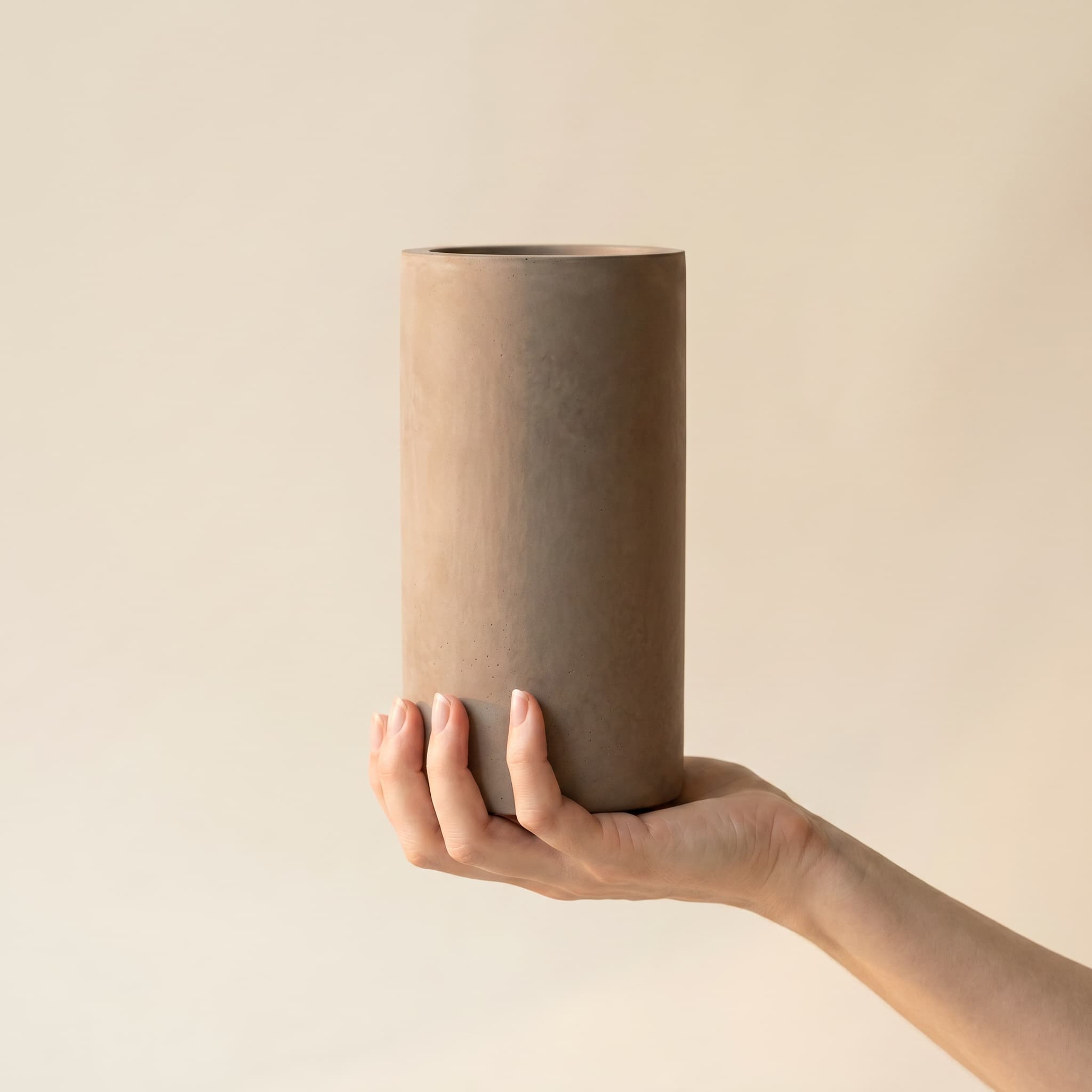 Tall taupe cylinder held in a hand